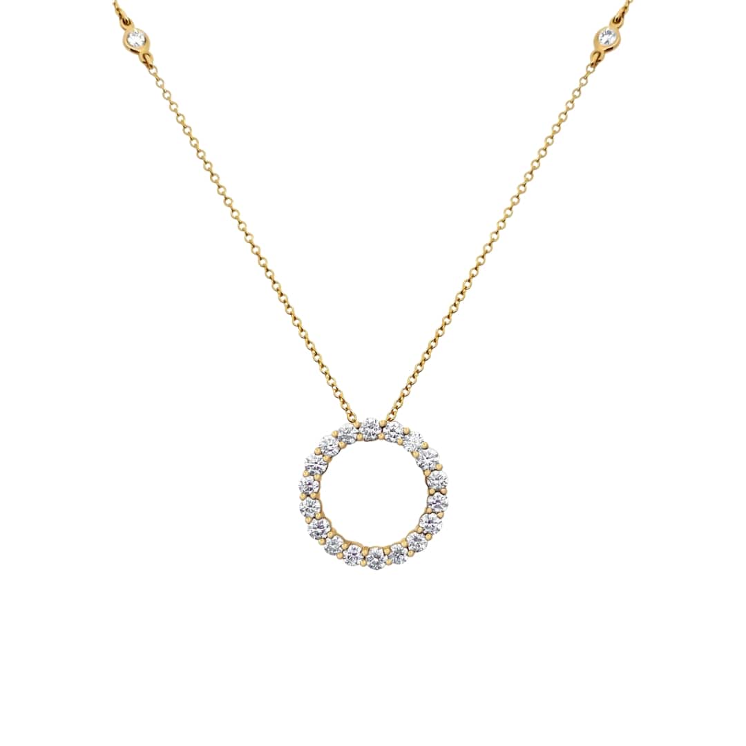 Gold necklace with a circular pendant on a white background